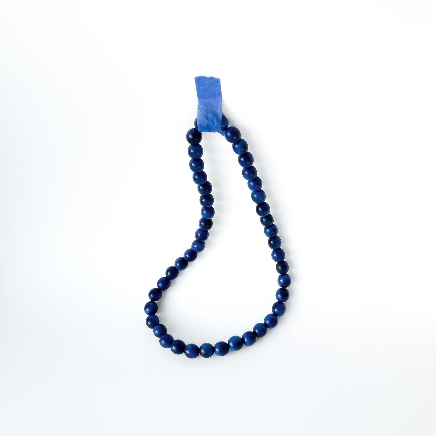 Blue beaded tagua necklace on a white background