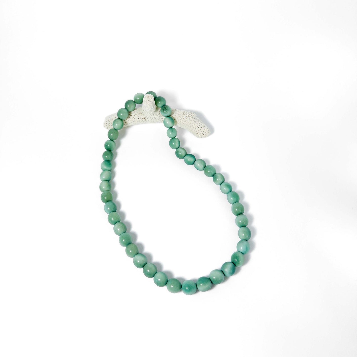 Green beaded tagua necklace on a white background